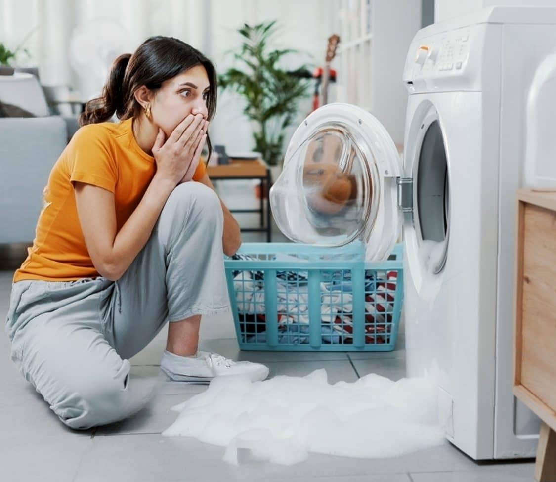 stock-photo-woman-checking-her-damaged-washing-machine-the-floor-is-flooded-2179959017