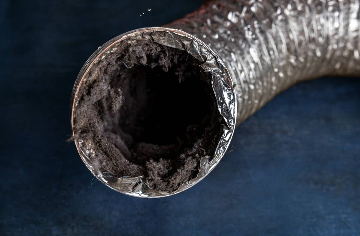 stock-photo-a-dirty-laundry-flexible-aluminum-dryer-vent-duct-ductwork-filled-with-lint-dust-and-dirt-against-2243539959