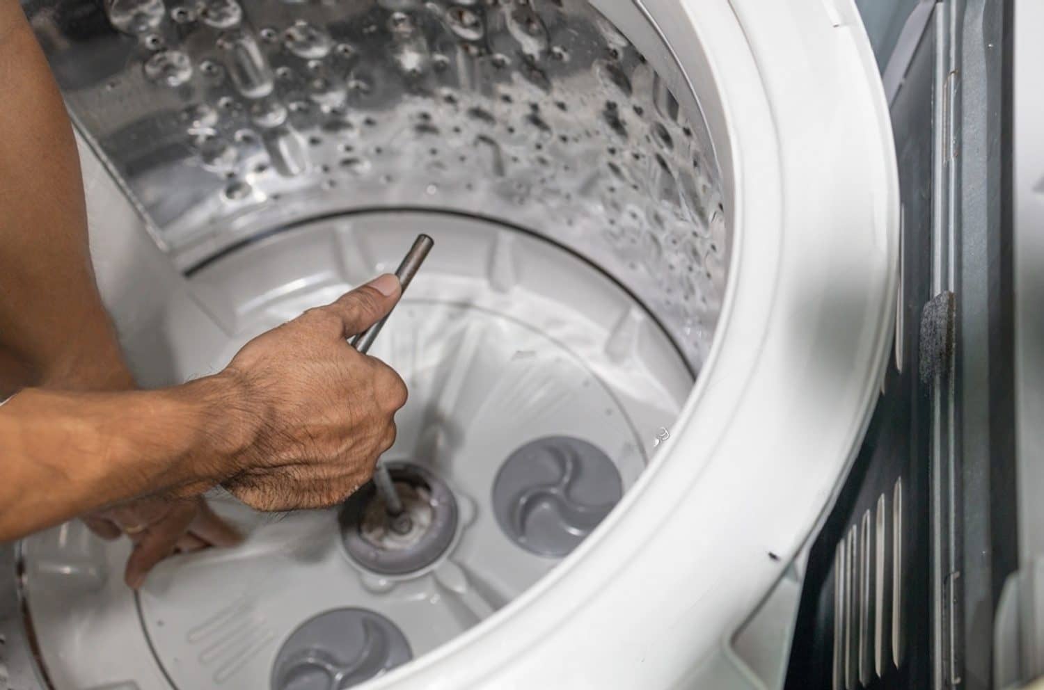 stock-photo-hands-of-repairman-using-t-type-wrench-screwing-the-nut-of-the-washing-machine-after-repairing-or-2049863627